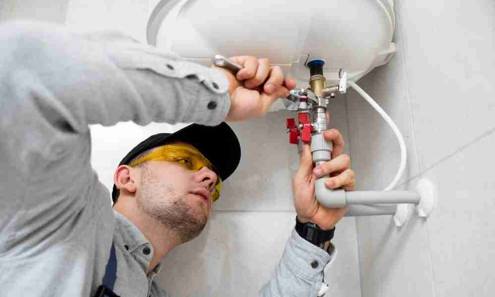 worker repairing tankless water heater