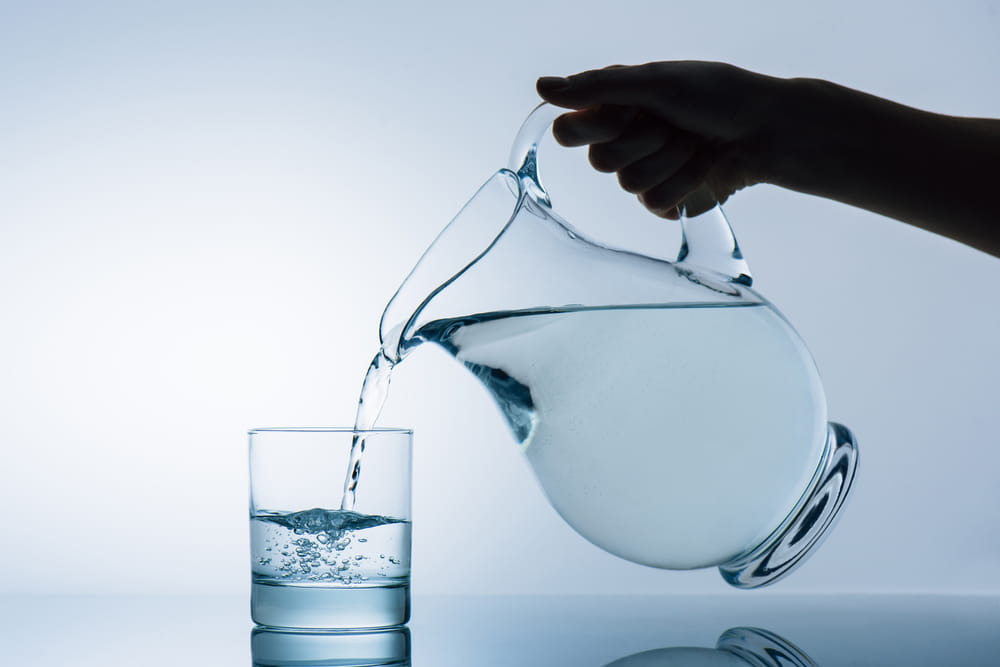 Woman Pouring Water in Glass