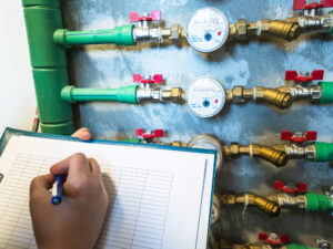 woman reading the water meter in the apartment building