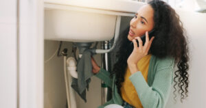 sink leak, plumbing and woman on a phone call for maintenance, plumber service and home construction. communication, manual labour and stressed girl calling handyman for faucet, pipes or kitchen leak